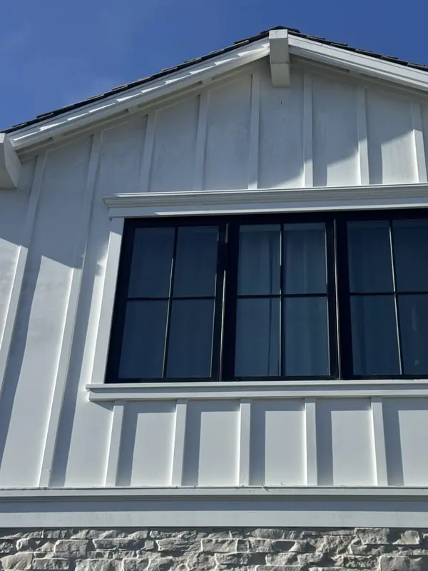 White painted board-and-batten siding gray with mildew before a soft wash