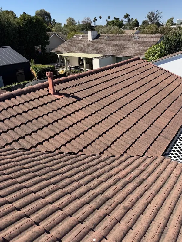 Red clay tile roof dark and blotchy with growth before a soft wash