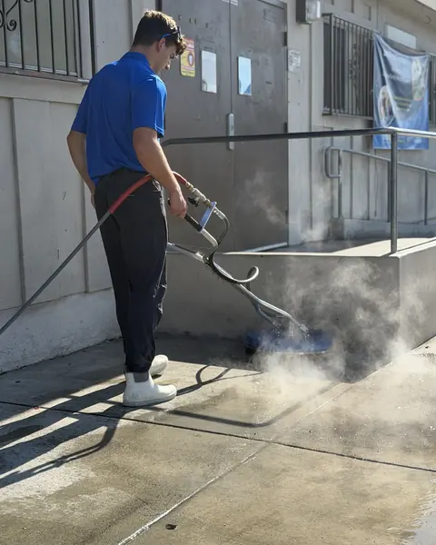 Titan crew member running a surface cleaner along the Boys and Girls Club building