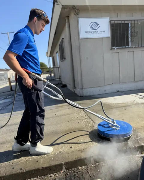 Titan crew member running a surface cleaner outside the Boys and Girls Club
