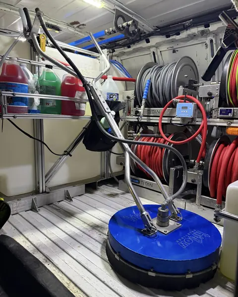 A surface cleaner loaded in the Titan van with hose reels behind it